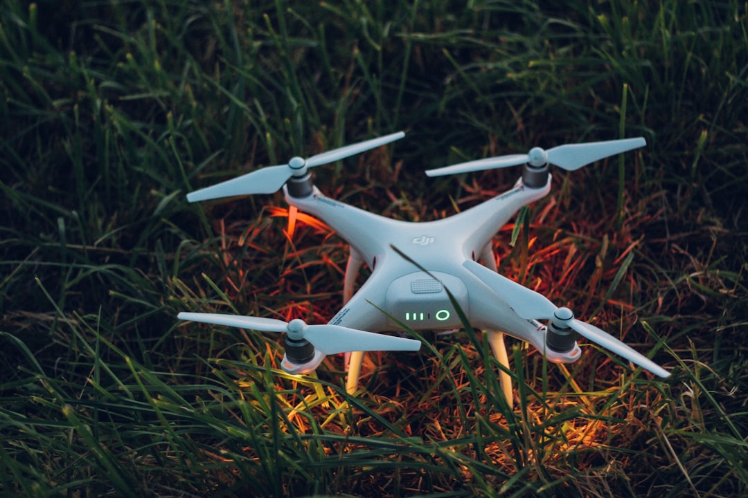 white and orange drone on green grass during daytime