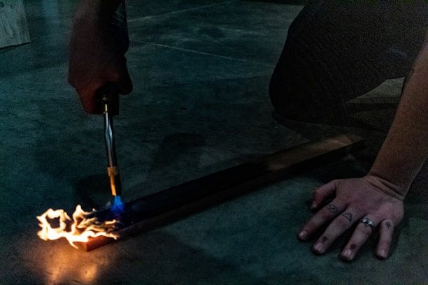 Close-up of a hand carefully burning a detailed wood stencil using the SGI realist pirography method.