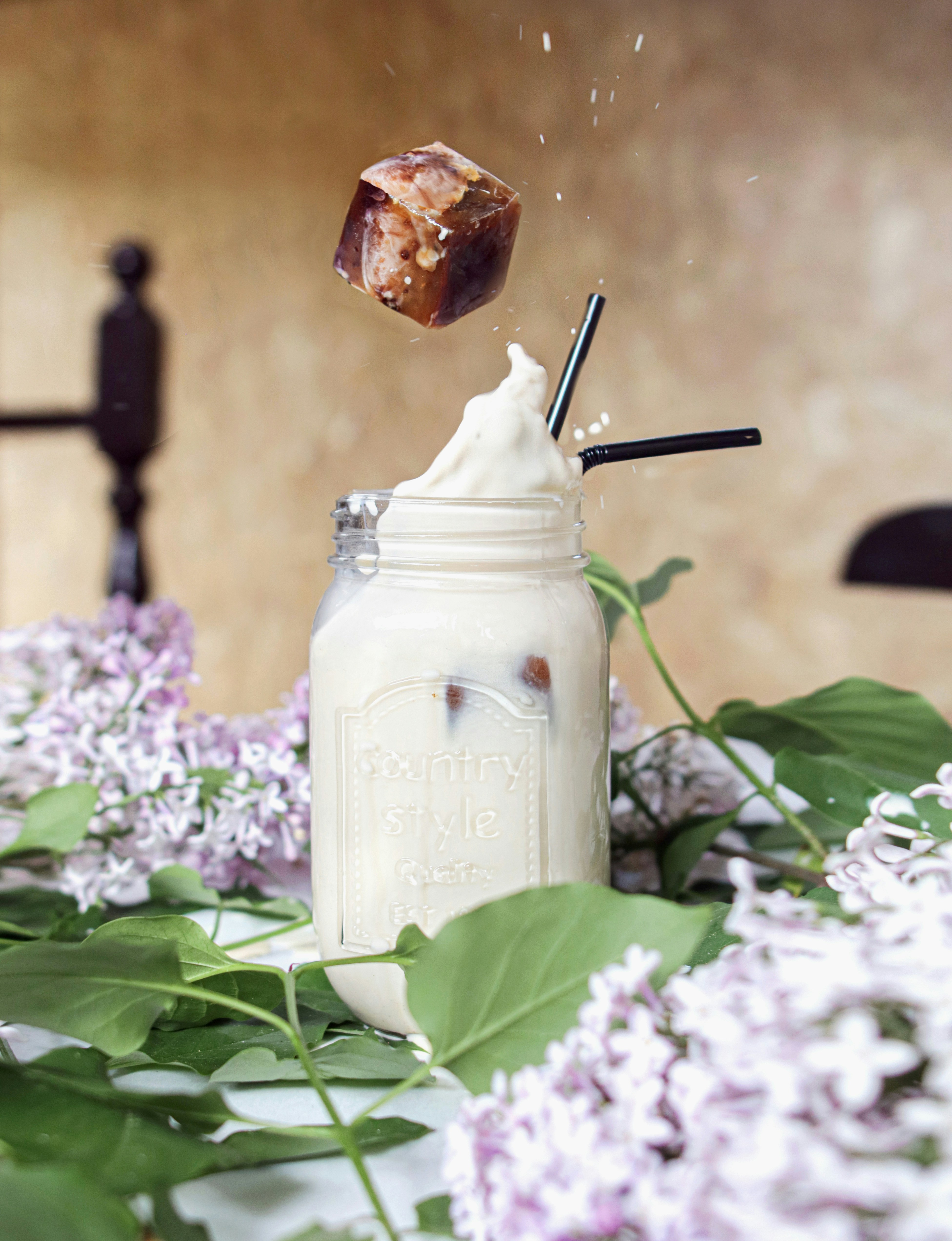 white liquid in clear glass jar with black straw