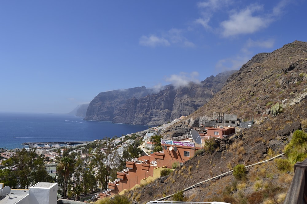 houses on mountain near body of water during daytime