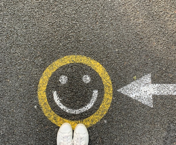 person in white shoes standing on gray concrete road