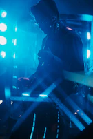 Dynamic shot of Tony playing guitar on stage with colorful lighting effects.