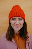 woman in orange knit cap smiling