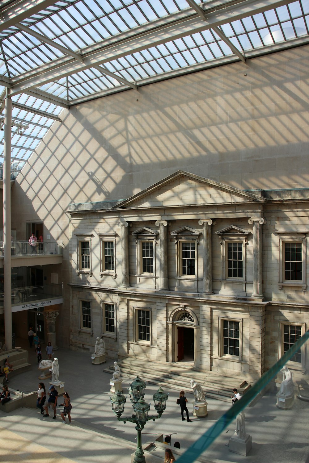 personnes marchant devant un bâtiment en béton beige pendant la journée