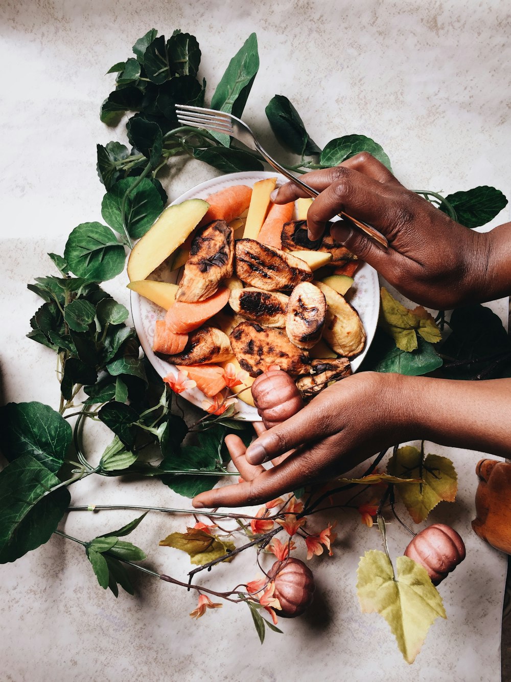 person holding sliced fruits on green leaves