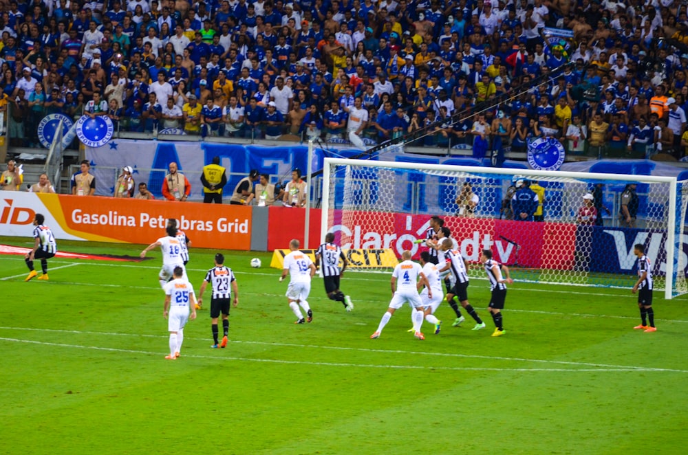 a group of soccer players playing a game of soccer