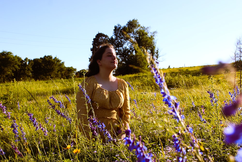 woman in yellow shirt standing on green grass field during daytime