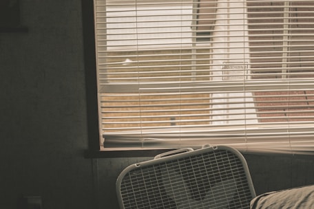 A sleek stand fan in a bright living room with sunlight streaming through the window.