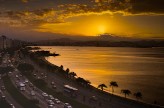 Elegant golden sunset over Pattaya city skyline with a luxury tour bus in the foreground.