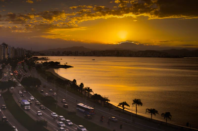 Elegant golden sunset over Pattaya city skyline with a luxury tour bus in the foreground.