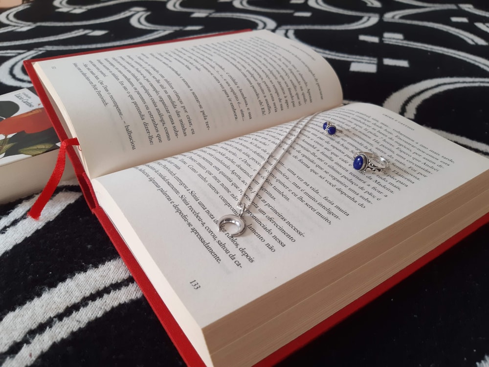 silver and gold necklace on book page