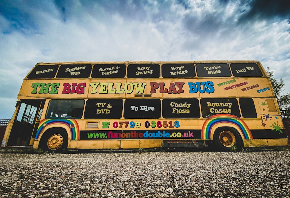 yellow red and blue bus on gray sand during daytime