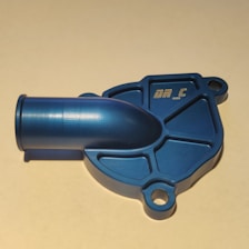 A blue mechanical component with a shiny finish, featuring a cylindrical extension and a base with multiple mounting holes. The surface has a textured pattern and some engraved text.