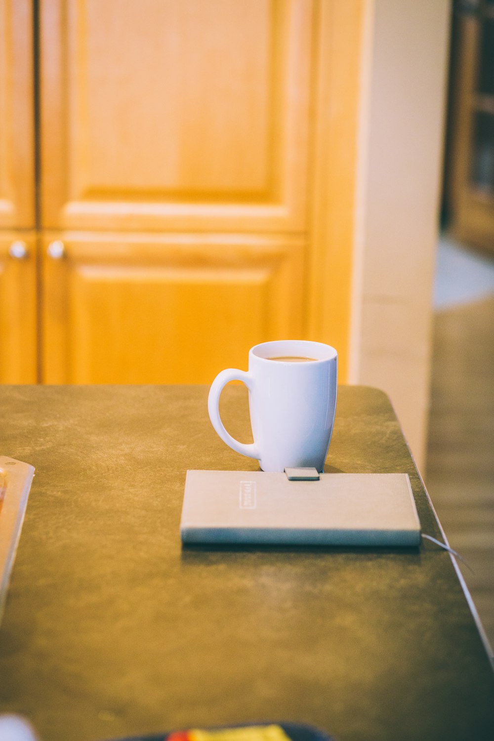 white ceramic mug on blue book