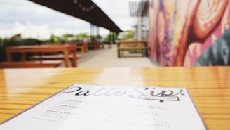 A colorful daily menu board with fresh dishes and drinks displayed on a rustic wooden table.