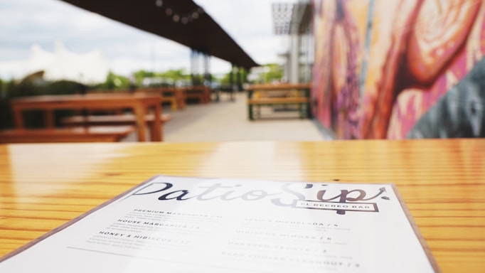 A colorful daily menu board with fresh dishes and drinks displayed on a rustic wooden table.