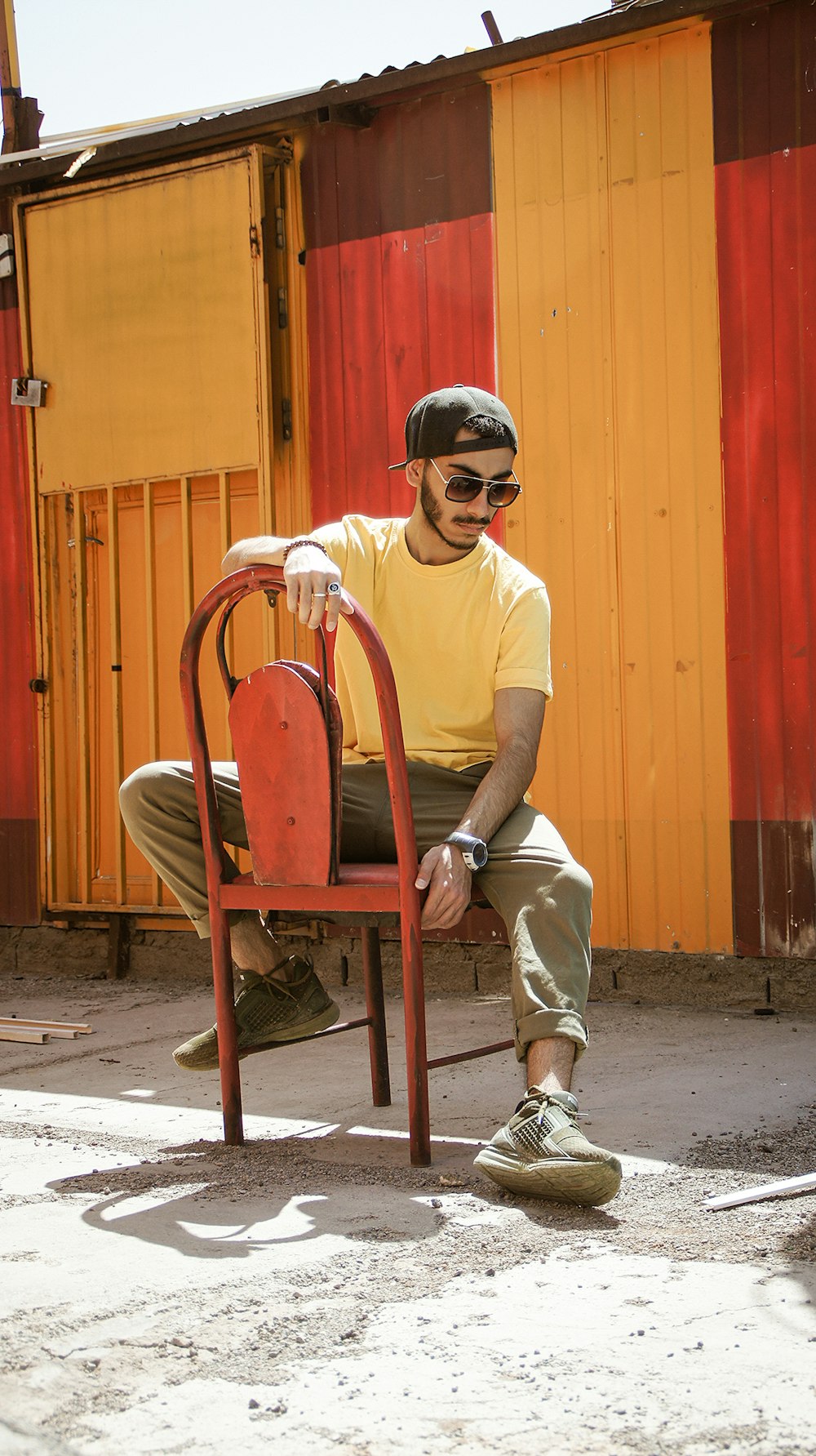 man in white crew neck t-shirt sitting on brown wooden chair