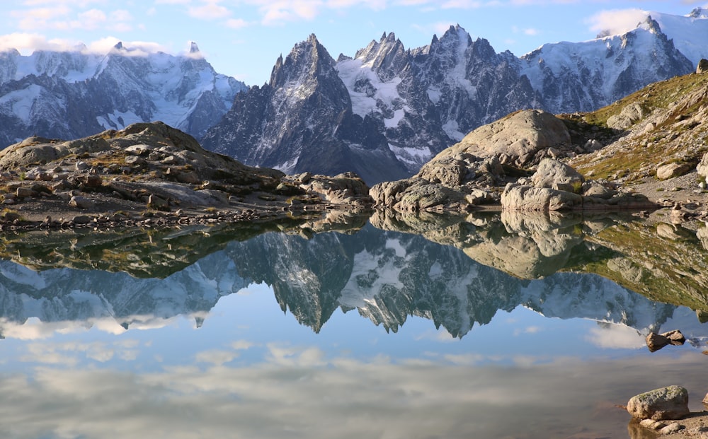 snow covered mountain near body of water during daytime