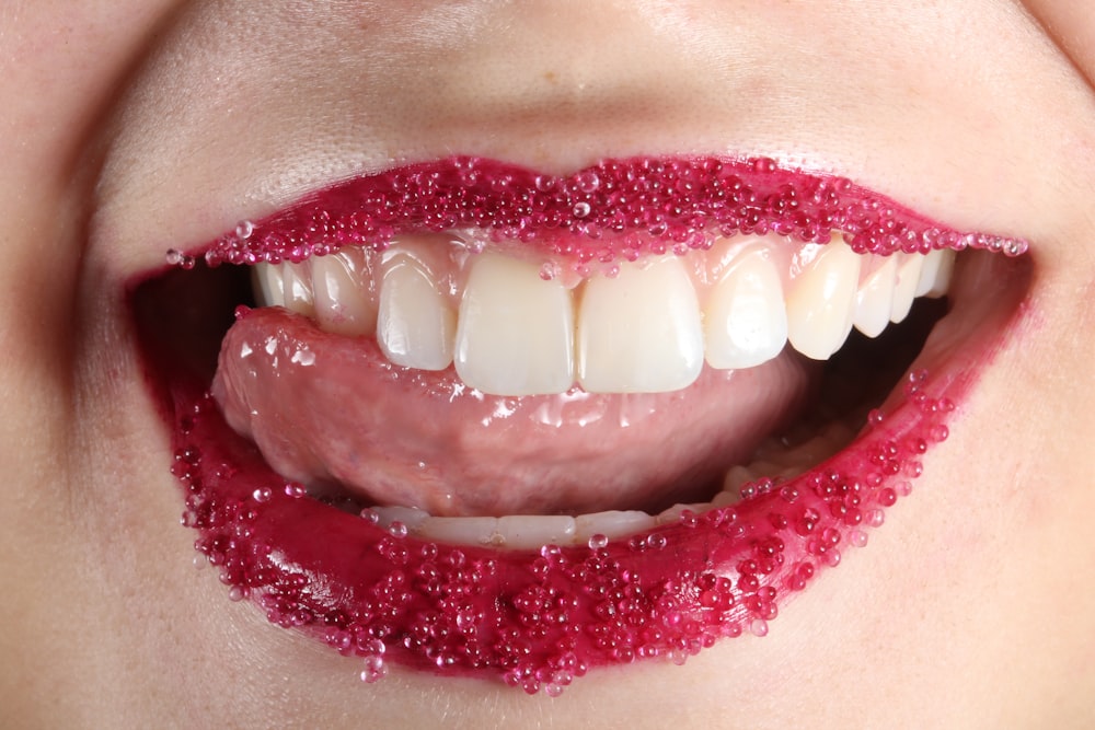 personne avec du rouge à lèvres rouge et des dents blanches