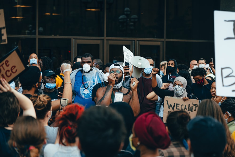 des gens en chemises bleues et chapeau blanc debout dans la rue pendant la journée