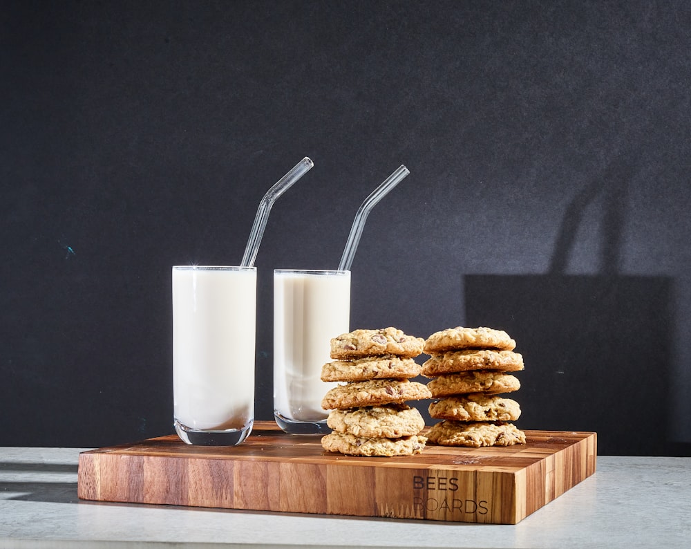 clear drinking glass with white liquid inside beside brown cookies