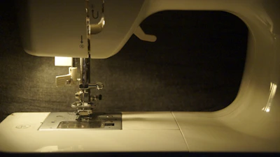 A variety of sewing machine parts laid out on a clean white surface.