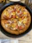 A happy customer enjoying a cheesy deep-pan pizza at Cheezy Slice in Model Town.