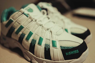 white and green adidas athletic shoes