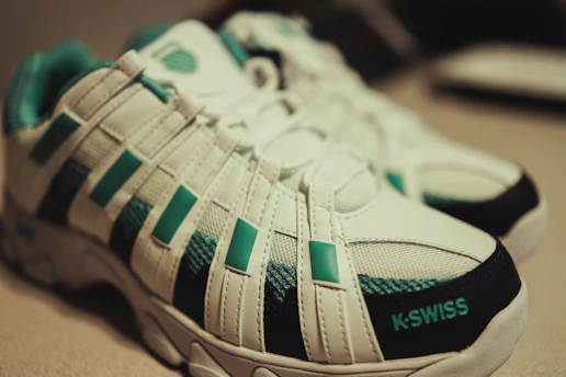 white and green adidas athletic shoes