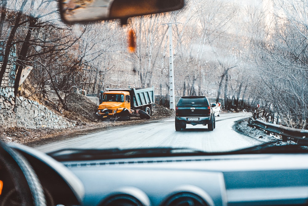 yellow and black truck on snow covered road during daytime