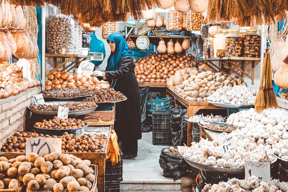 woman in blue jacket standing in front of food stand