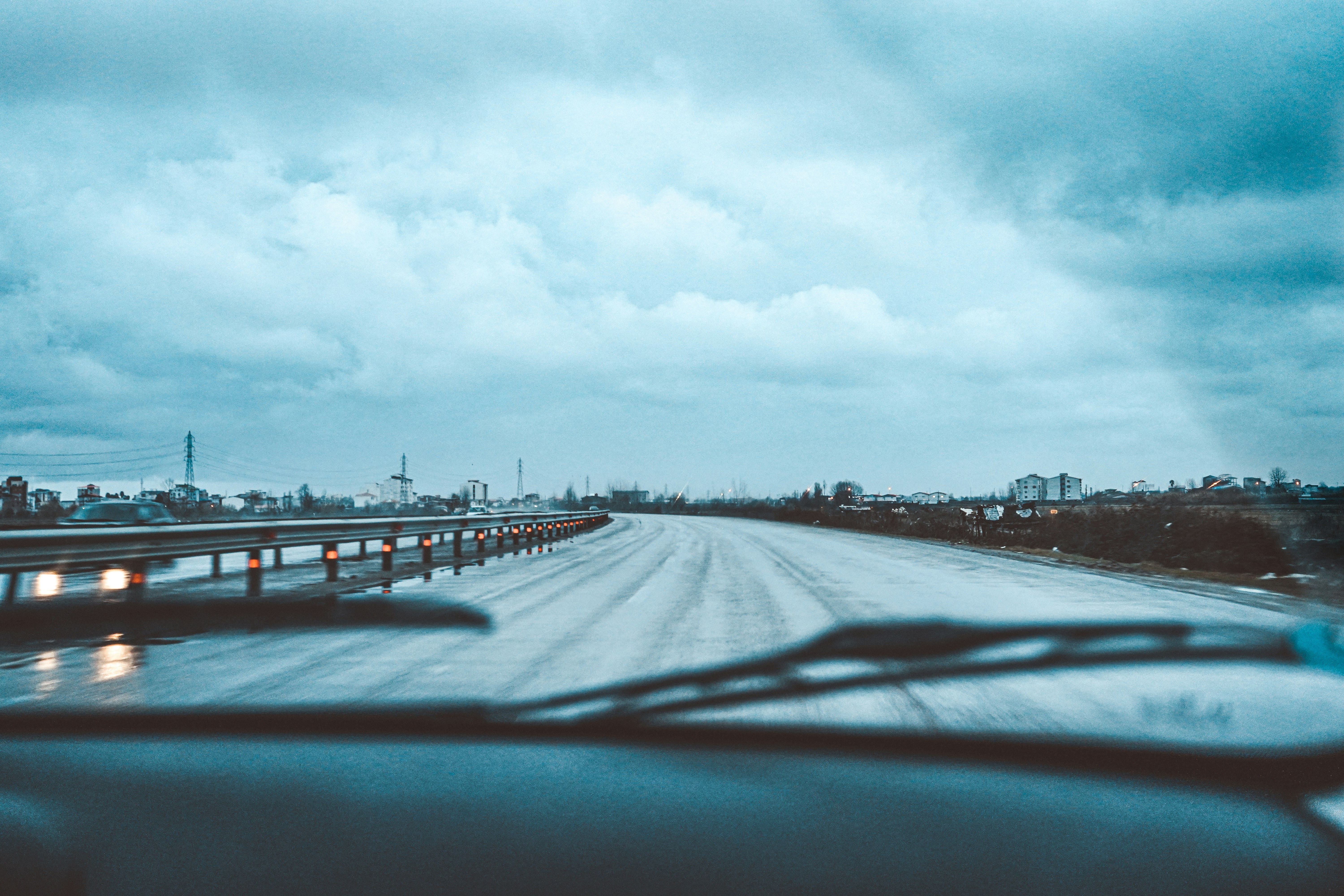 body of water near city buildings under white clouds and blue sky during daytime