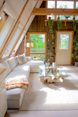 Bright living room with a white couch and potted plant, showing a furnished rental space in the Las Vegas valley