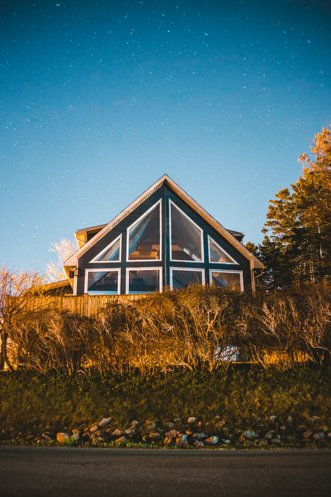 brown and white wooden house surrounded by green grass field during daytime