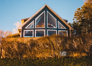 brown and white wooden house surrounded by green grass field during daytime