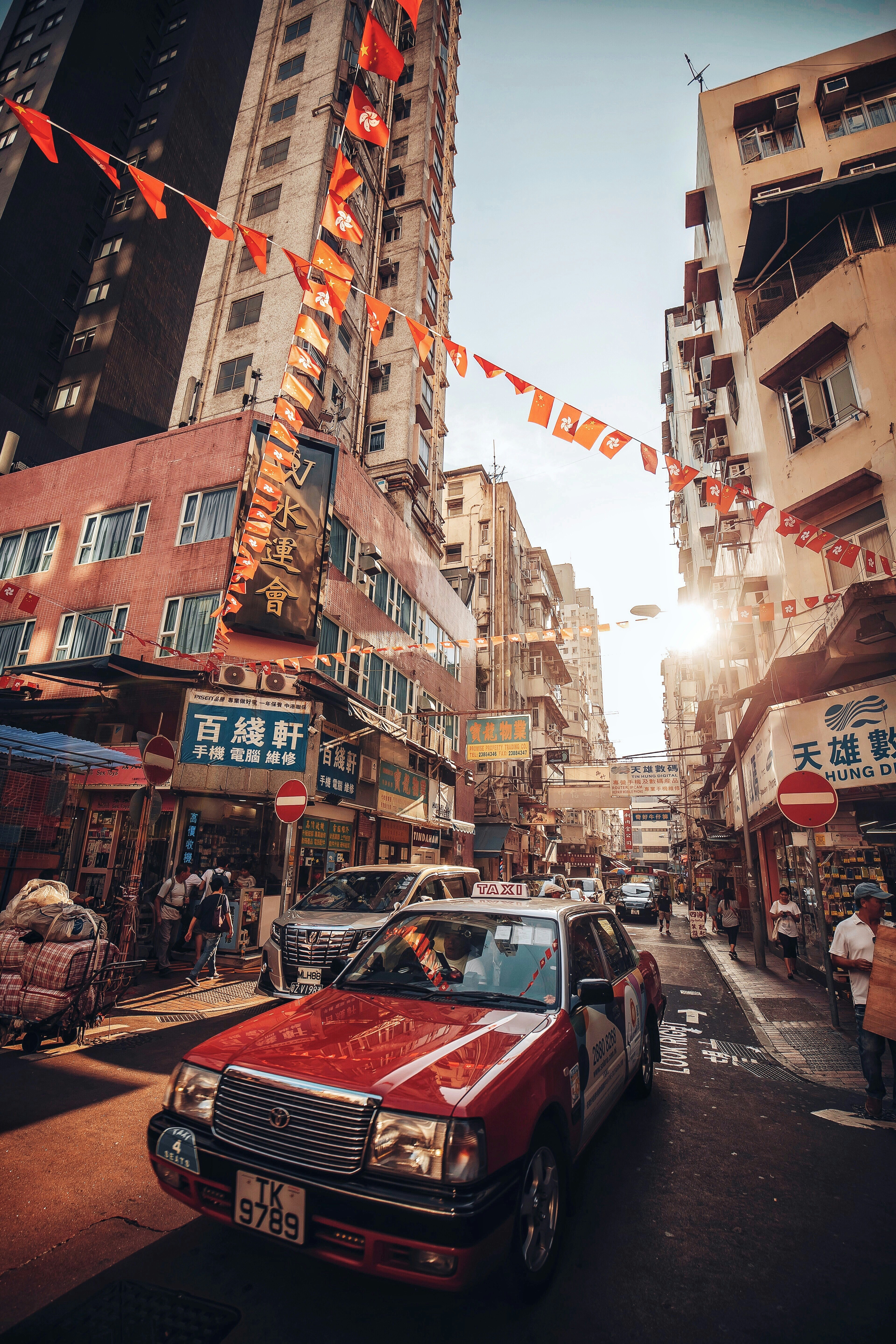 cars on road between buildings during daytime