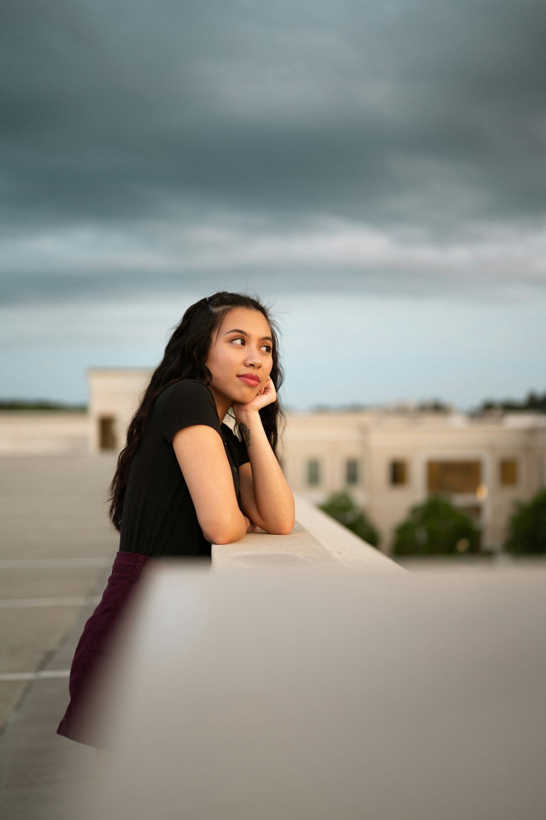 woman in black dress sitting on white bench during daytime