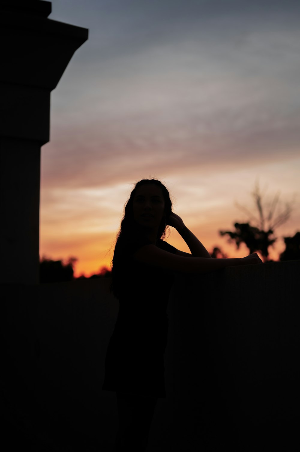woman in black dress standing during sunset