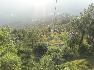 A colorful ropeway gliding over the forested slopes near Kharagpur Hill, offering breathtaking views