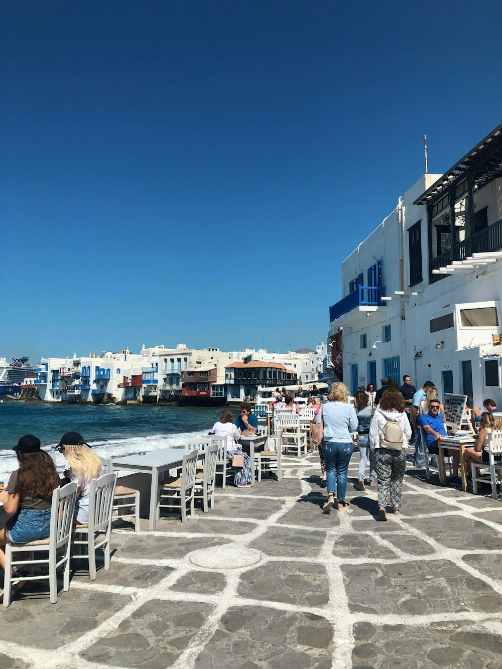 people walking on the street near the beach during daytime