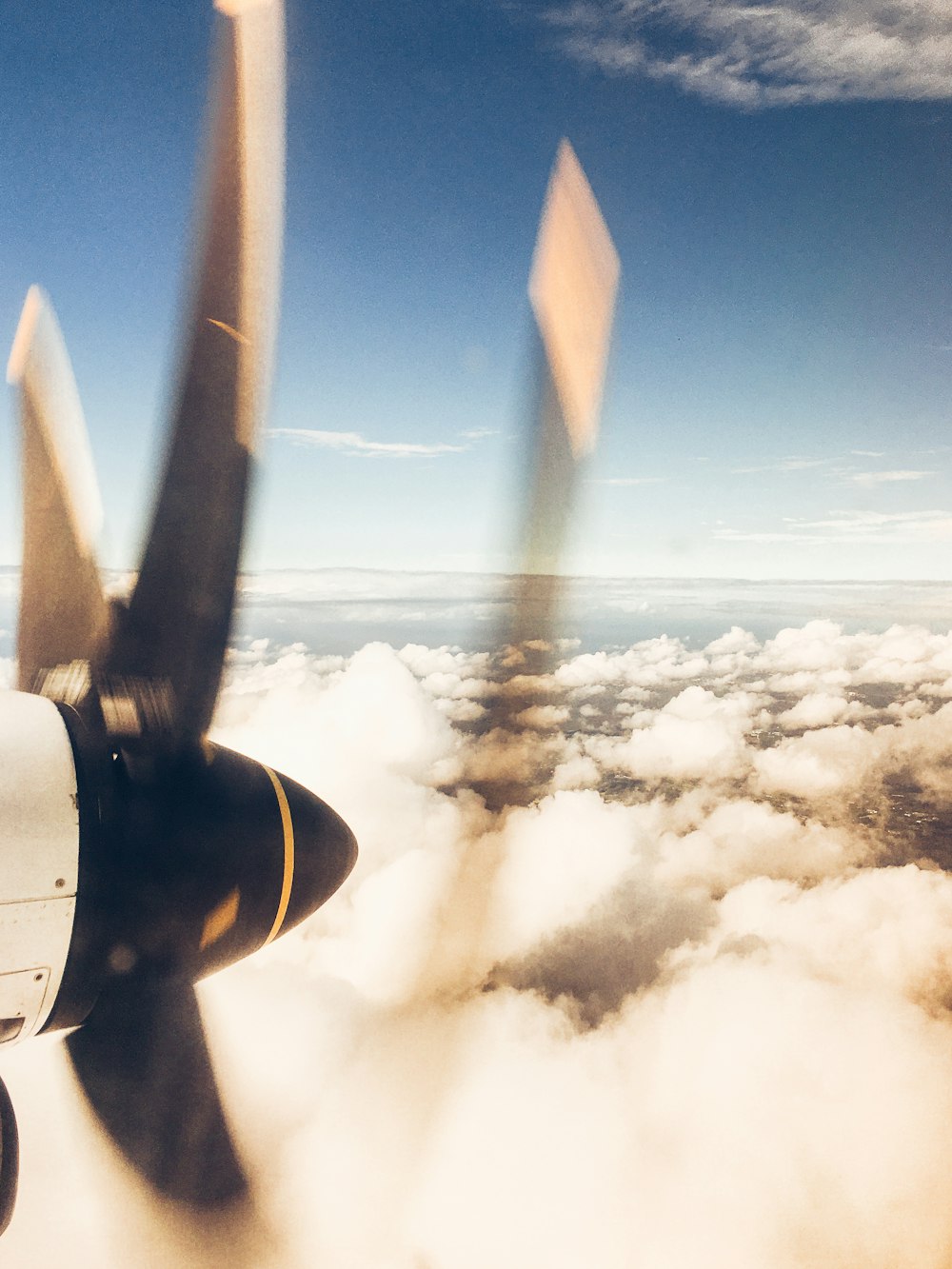 airplane flying over clouds during daytime