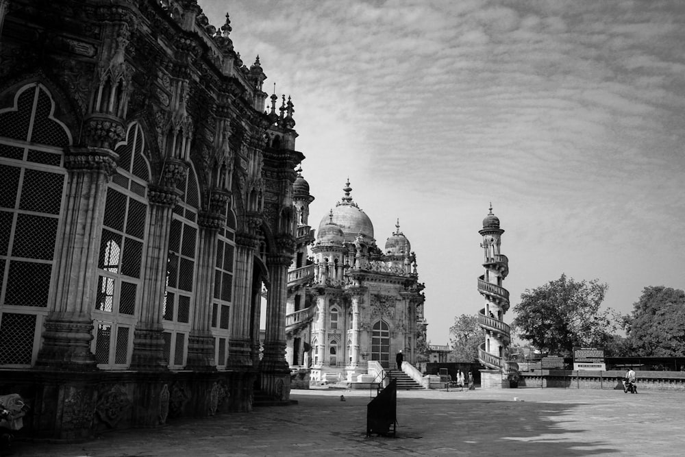 grayscale photo of man standing near building