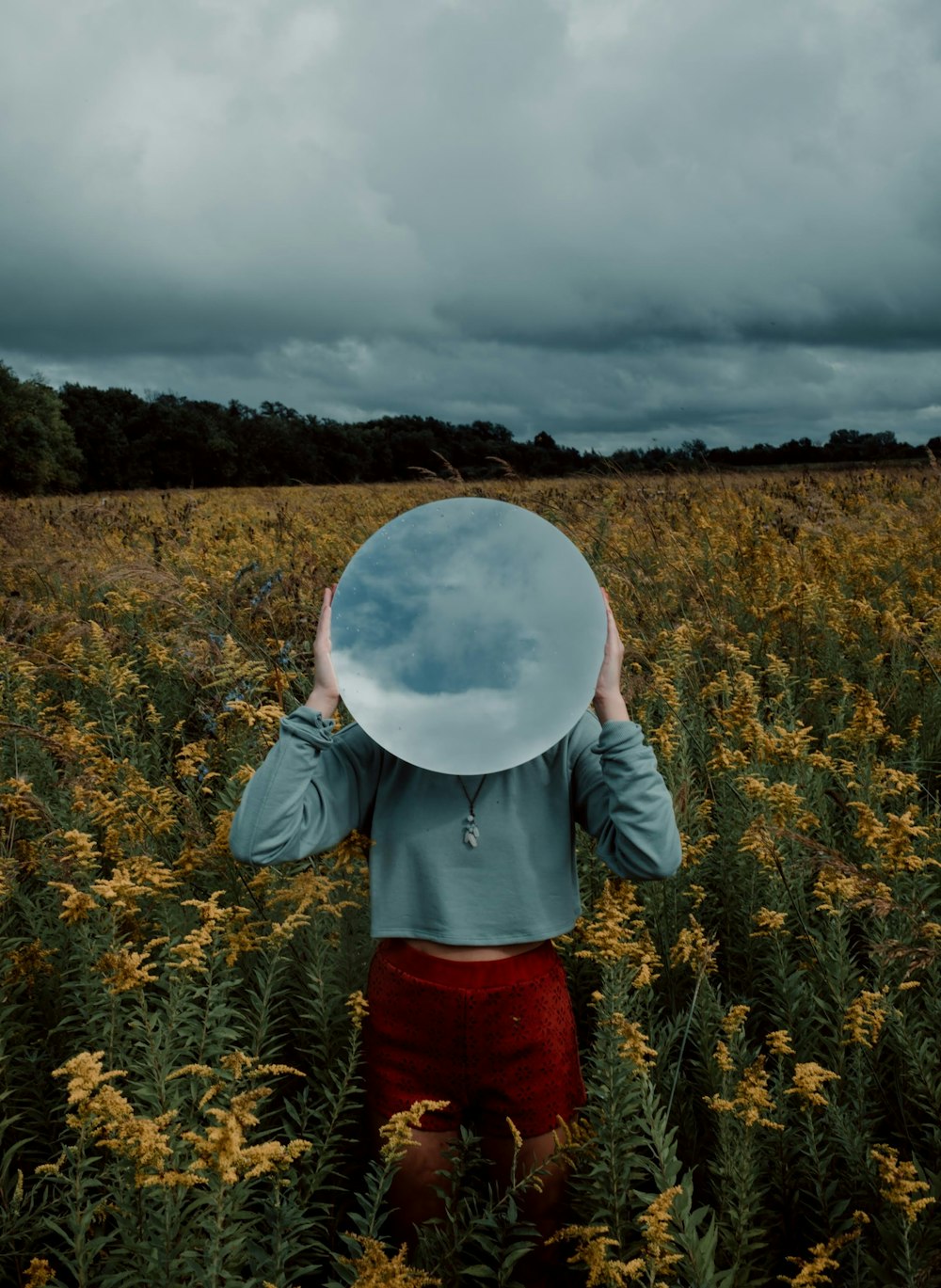 person in red and black long sleeve shirt holding white round ball