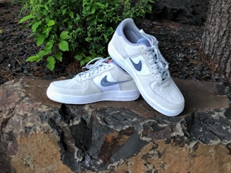 Pair of lightweight sports shoes resting on mossy ground with mountain backdrop