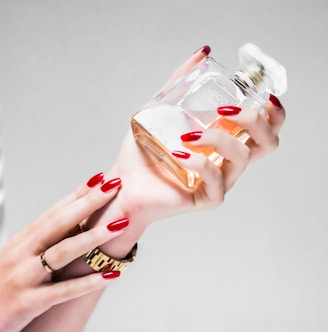 person holding clear glass bottle