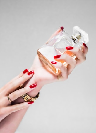 person holding clear glass bottle