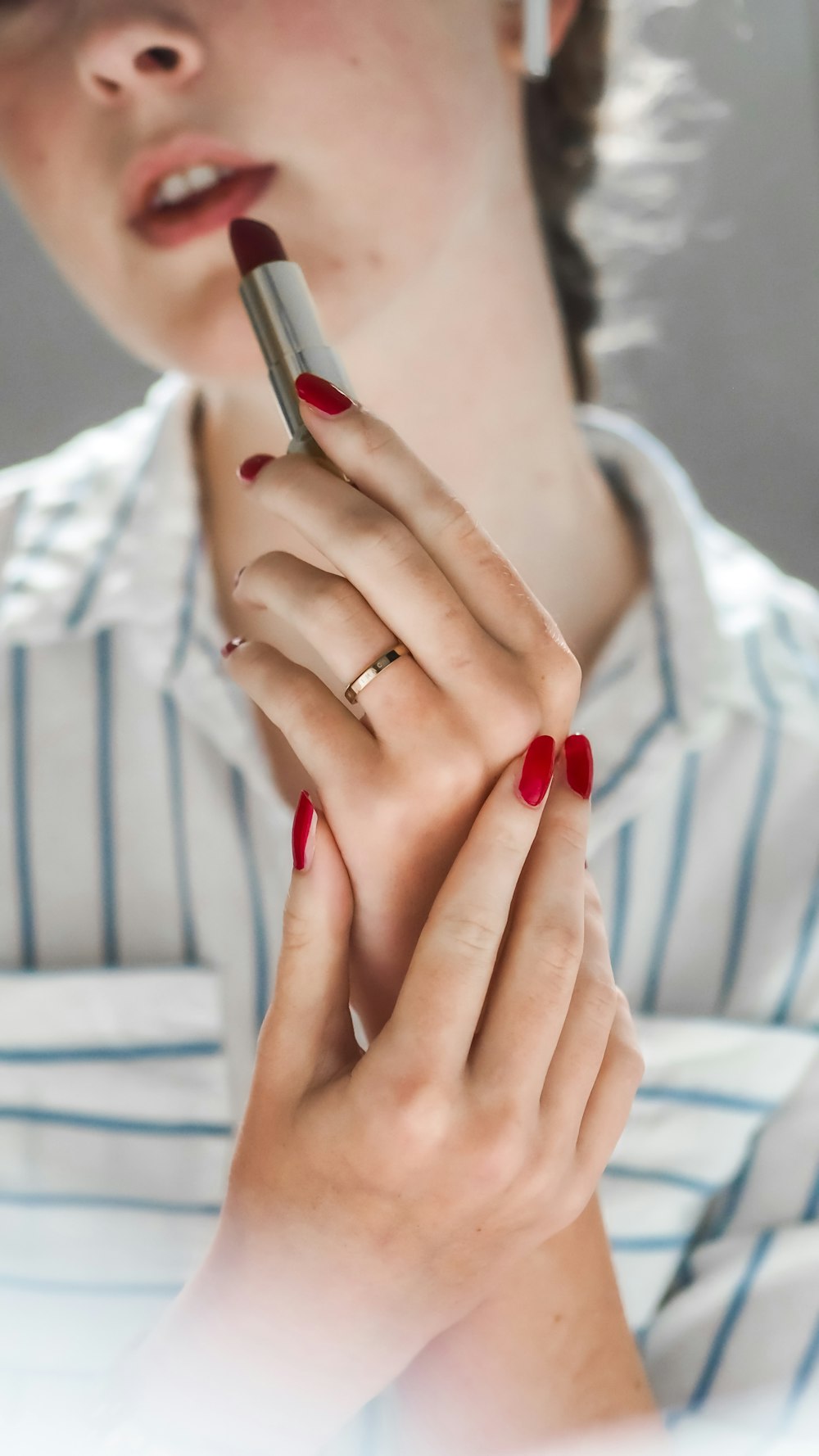 Mujer con manicura roja y anillo dorado