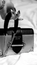 Minimalist black and white photo of a sleek modern handbag on a white background