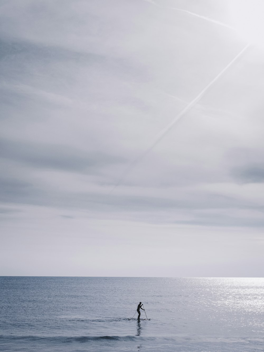 person in boat on sea under cloudy sky during daytime