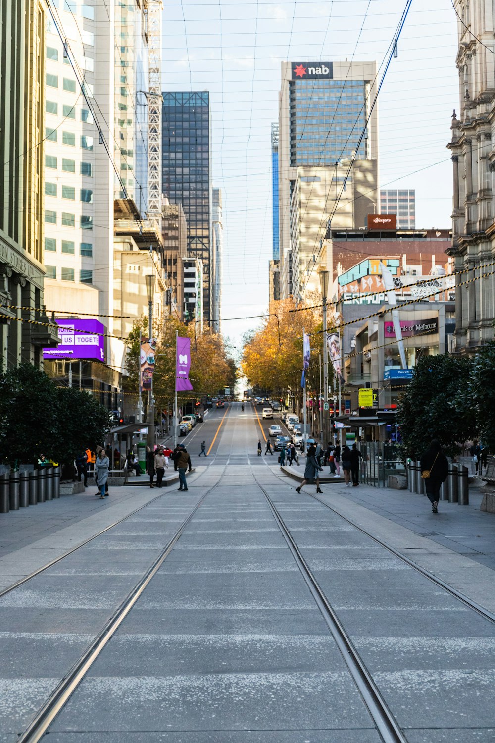 people walking on sidewalk near high rise buildings during daytime